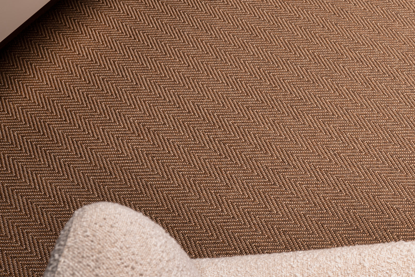 Brown textured carpet with a herringbone pattern